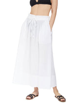Close up shot of model wearing fresh white midi length skirt with side slits and elastic waistband with drawstring detail with black v-neck bikini top and black sandals