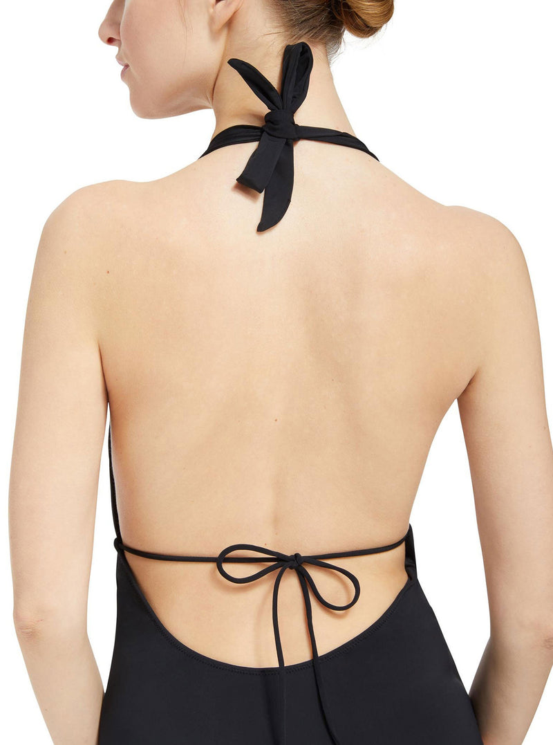 back close up shot of Model wearing black deep plunged one piece swimsuit with an adjustable halter-neck tie and under-bust string 