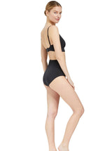 Side of a model wearing a black scoop neckline bikini top with under-bust band and adjustable straps with matching high rise bikini bottom 