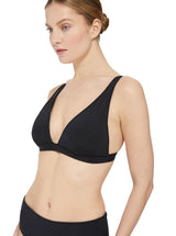 Model looking to the side and wearing a black plunge neckline, classic bikini topwith adjustable straps and an elastic underband with a matching classic midrise bikini botton