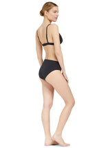 the side of Model wearing a black plunge neckline, classic bikini top with adjustable straps and an elastic underband with a matching classic midrise bikini bottom